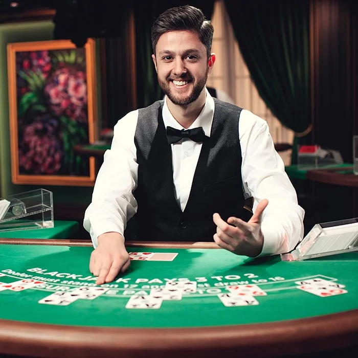 Professioneller Live Casino Dealer am Blackjack-Tisch mit zwei Assen in der Hand